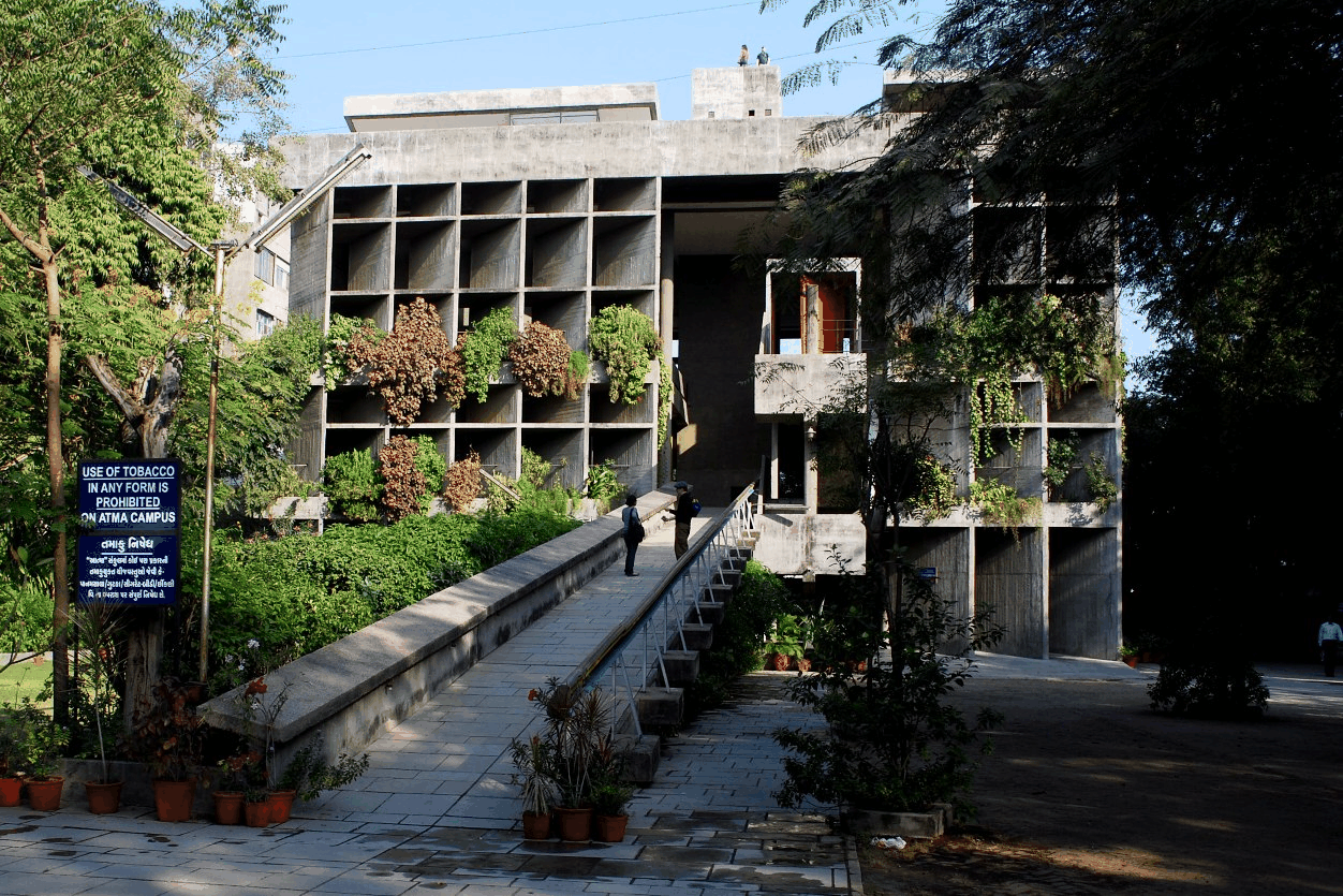 Whole facade of Mill Owners Association with its entrance ramp and surrounding trees