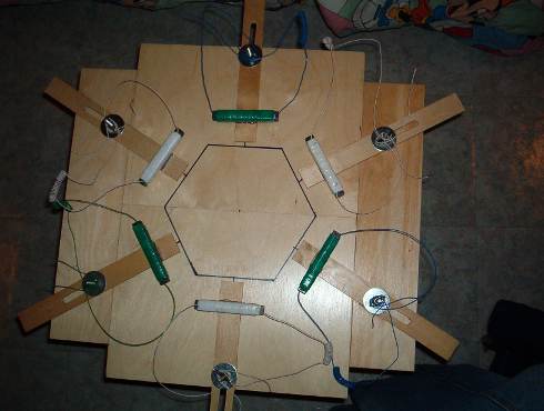 A modern Coler reconstruction, with coils and wiring arranged around a hexagon on a wooden board